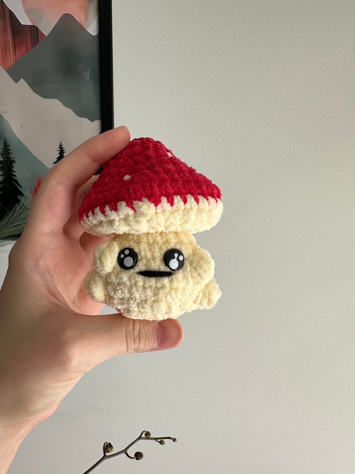 A small handmade amigurumi character in progress with stuffing and a stitch marker