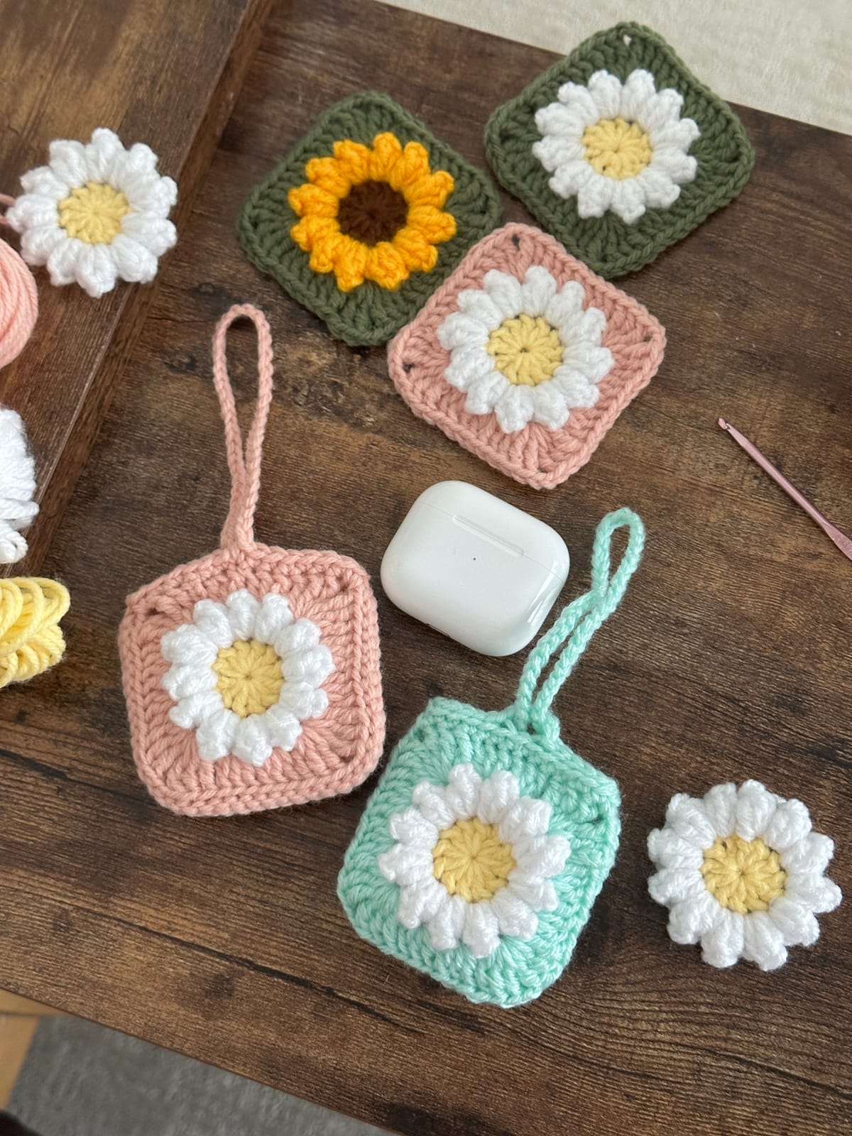 A small crochet coaster in progress beside a ball of soft beige yarn